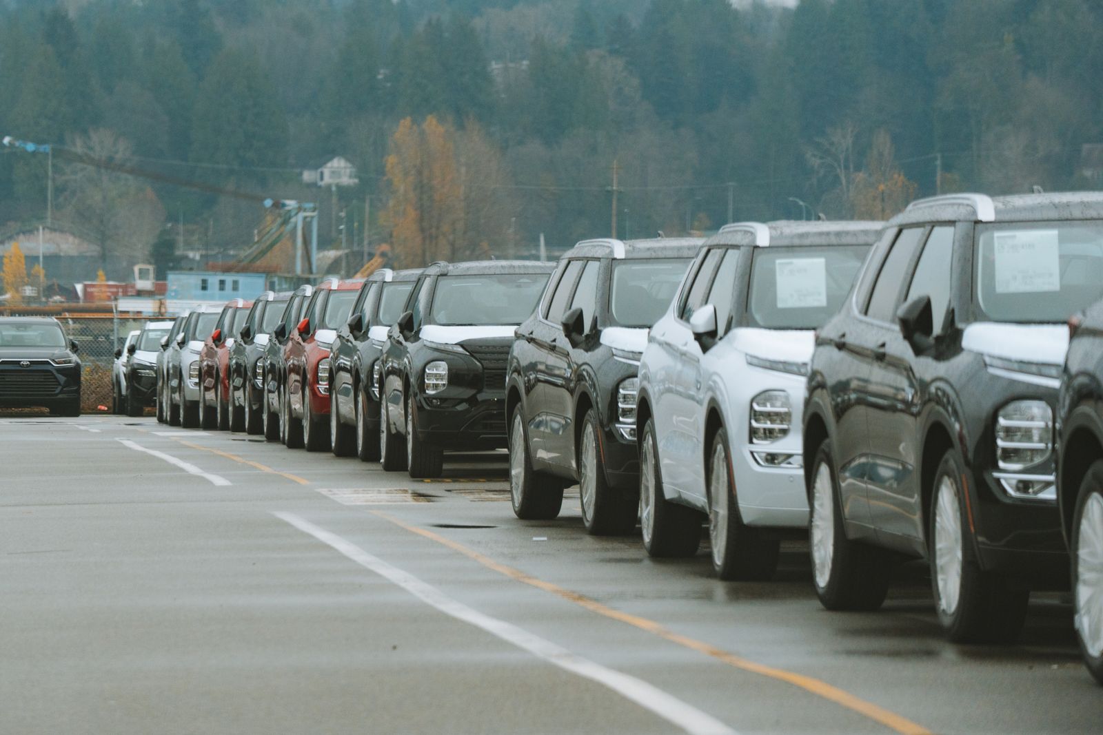 Rows of vehicles lined up on a dealership lot, waiting for reconditioning